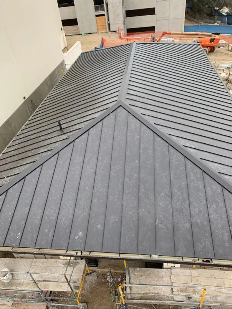 Commercial metal roof construction with crane equipment in Pauls Valley